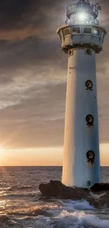 Lighthouse standing against a dramatic sunset over the ocean.