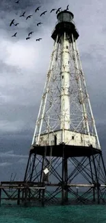 Lighthouse standing in the ocean with sea birds in the background.