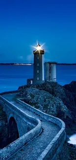 Lighthouse at twilight with a scenic ocean view under a deep blue sky.