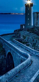 Serene dusk view of a lighthouse by the sea on coastal rocks.