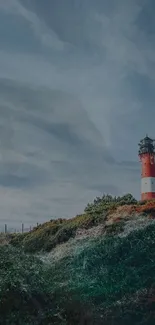 Lighthouse on a coastal cliff under a blue sky, ideal for mobile wallpaper.