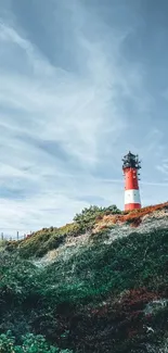 Scenic lighthouse view with blue sky and hilly landscape background.