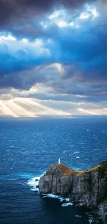 Vibrant ocean sunset with lighthouse and dramatic clouds over a rocky cliff.