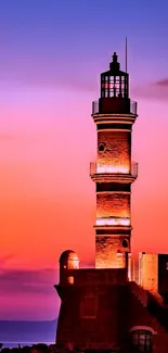 Lighthouse against a vibrant sunset sky with hues of purple and orange.