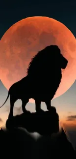 Lion silhouette against an orange full moon backdrop in a nighttime setting.