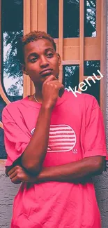 Person in pink shirt posing against textured backdrop