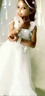 Little girl in elegant white dress posing against a plain wall.