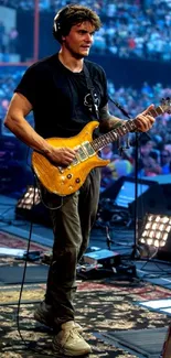 Musician playing guitar on a vibrant stage during a live concert.