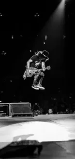 Guitarist mid-air during live rock concert on stage.