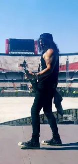 Musician performing on a large stage in an empty stadium.