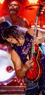 Guitarist performing live on stage with vibrant red lights.