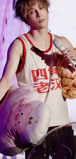 Energetic concert moment with performer holding plush toys on stage.