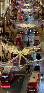 London street with Christmas lights and red buses at night.