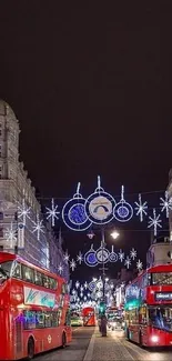 London city street at night with buses and festive lights.