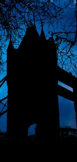 London Tower Bridge silhouette at night with dark blue sky.