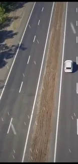 Aerial view of a car driving on an empty highway.