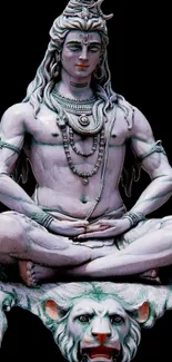 Intricate statue of Lord Shiva sitting in a meditative pose against a dark background.