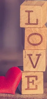 Wooden blocks spelling love with red heart.