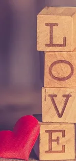 Wooden blocks with red heart spell 'LOVE' on mobile wallpaper.