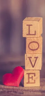 Wooden blocks spelling LOVE stacked with a red heart beside them.