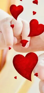Baby and parent hand with red love hearts touching.