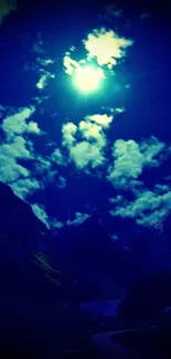 Moonlit mountain landscape with blue night sky and scattered clouds.