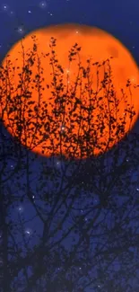 Orange full moon behind silhouetted tree branches.