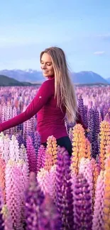 Woman in vibrant lupine fields with mountains in the background.