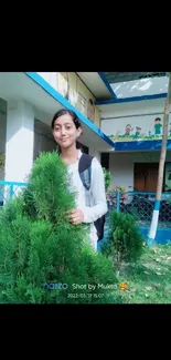 Young woman among lush greenery on campus.