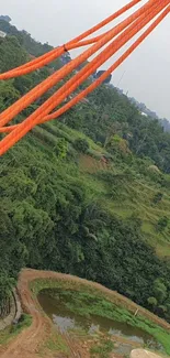 Orange ropes over lush green landscape wallpaper.