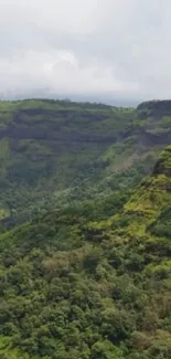 Green mountain landscape with misty peaks and lush greenery.