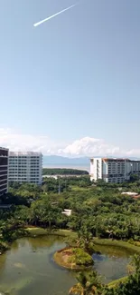 Urban resort surrounded by lush greenery and distant ocean view on a sunny day.