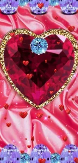 Heart-shaped red gem with blue and purple stones on silky pink background.