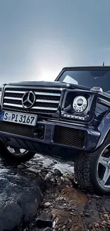 Luxury black SUV set on rocky terrain with a dark blue background.