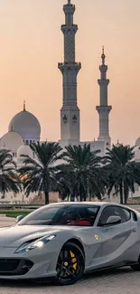 Luxury car in front of a mosque at sunset.