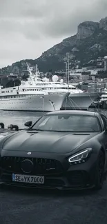 Luxury black car parked by a marina with yachts and city backdrop.