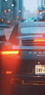 Luxury car driving in rainy city with glowing tail lights at night.