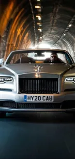 Luxury car driving through a tunnel with glowing headlights.