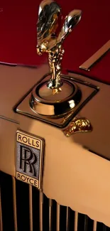 Gold car hood ornament on a red backdrop, exuding luxury and elegance.