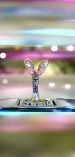 Luxury car hood ornament with pink tones and elegant design.