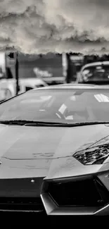 Black and white sports car under cloudy sky.