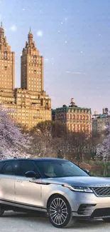 Luxury car in scenic park with cherry blossoms and skyscrapers in the background.