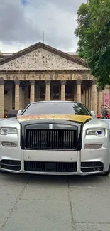 Luxury car front view with historic building backdrop.