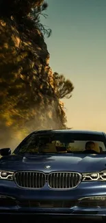 Luxury blue car driving on a mountain road at sunset.