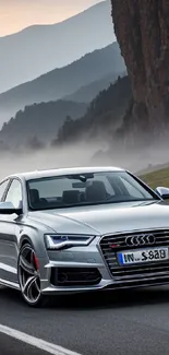 Luxury car driving on a scenic mountain road with misty hills.