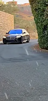 Luxury black sedan driving on scenic road with stone walls and greenery.