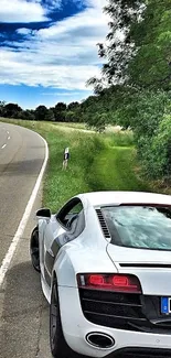 Luxury sports car on a winding scenic road.