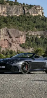 Luxury car set against a scenic mountain backdrop on a sunny day.