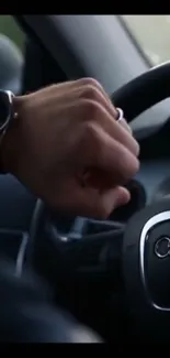 Hand on steering wheel with wristwatch in luxury car.