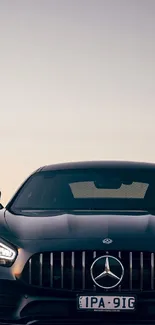 Luxury car silhouette at sunset in scenic background.